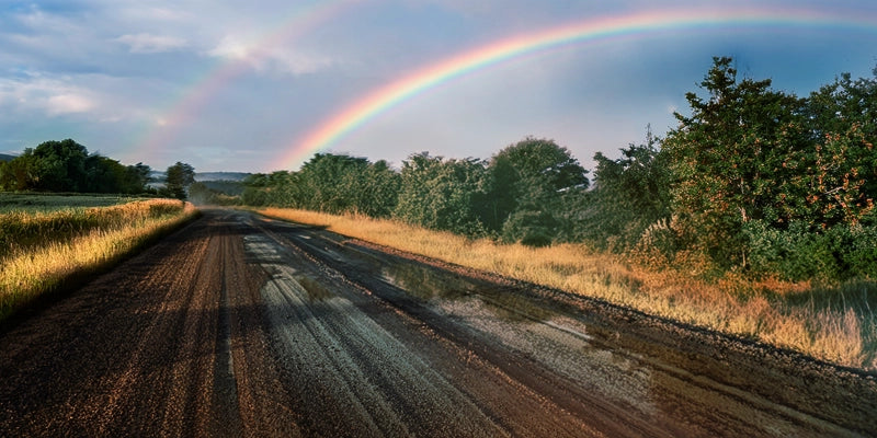 Double rainbow over a rural road after a light rain.