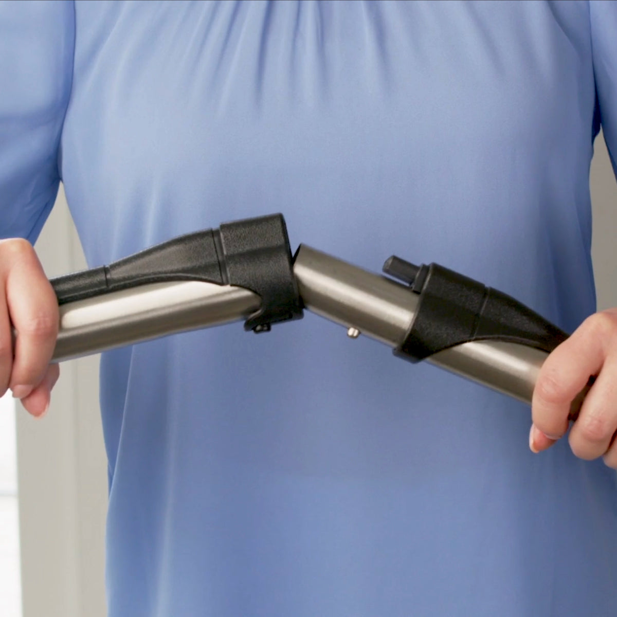 Person connecting two stainless steal wands.